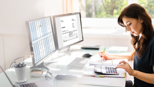Woman looking at finance invoices at her desk